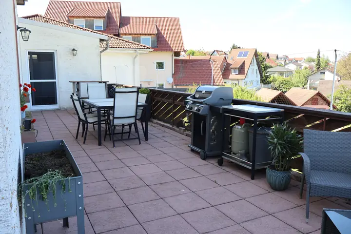 Terrace with outdoor dining table, grill and view over the village
